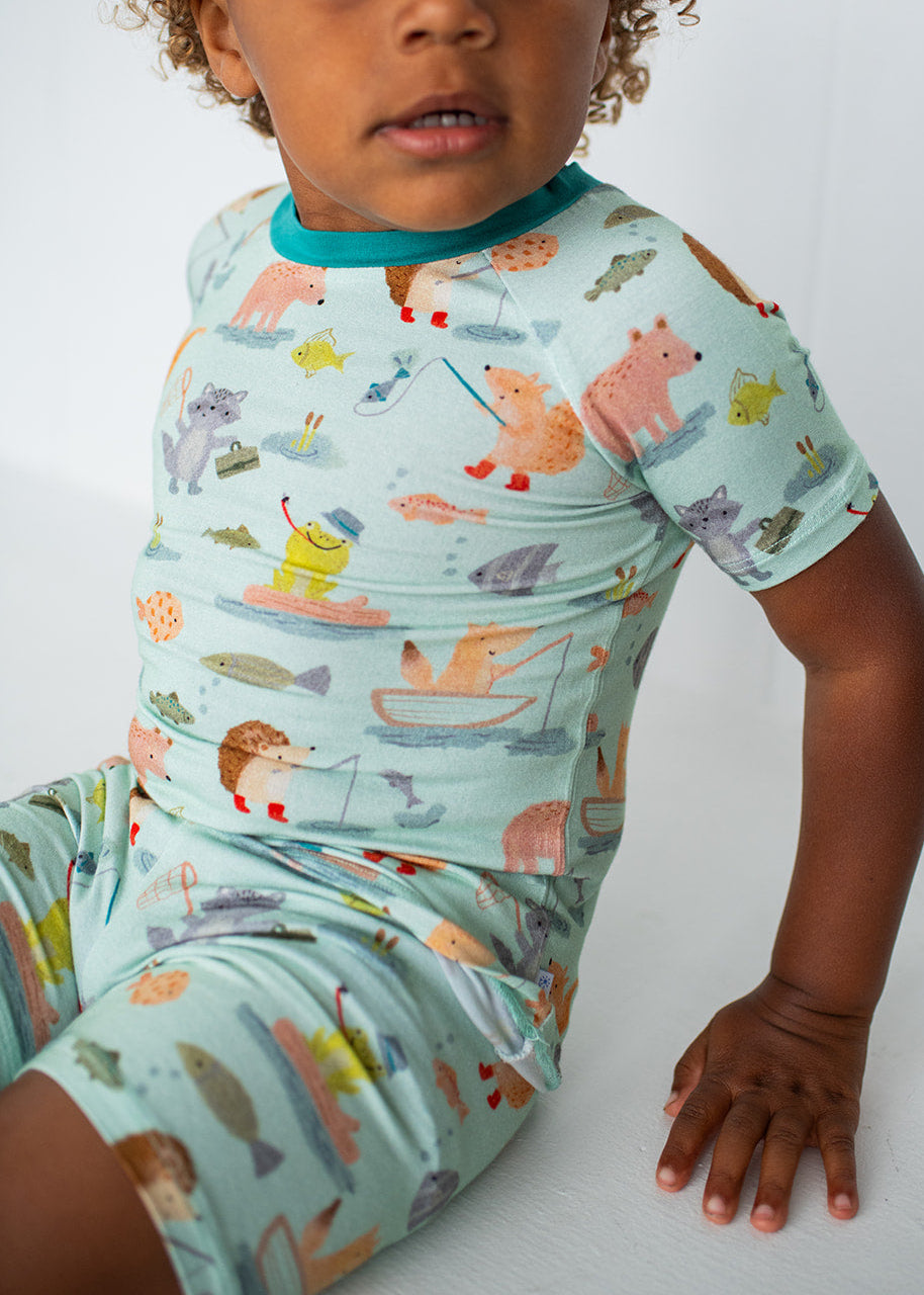 Child wearing a colorful pajama set with animal patterns on a white background