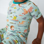Child wearing a colorful pajama set with animal patterns on a white background